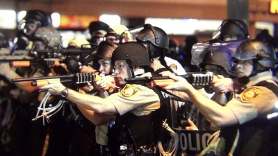Foto: Agentes da Polícia da cidade de Ferguson, estado de Missouri, apontam suas armas a um manifestante negro durante distúrbios provocados pelo assassinato de Michael Brown.